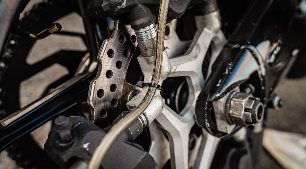 Detailed view of a motorcycle disc brake system, focusing on the brake and hose connections.